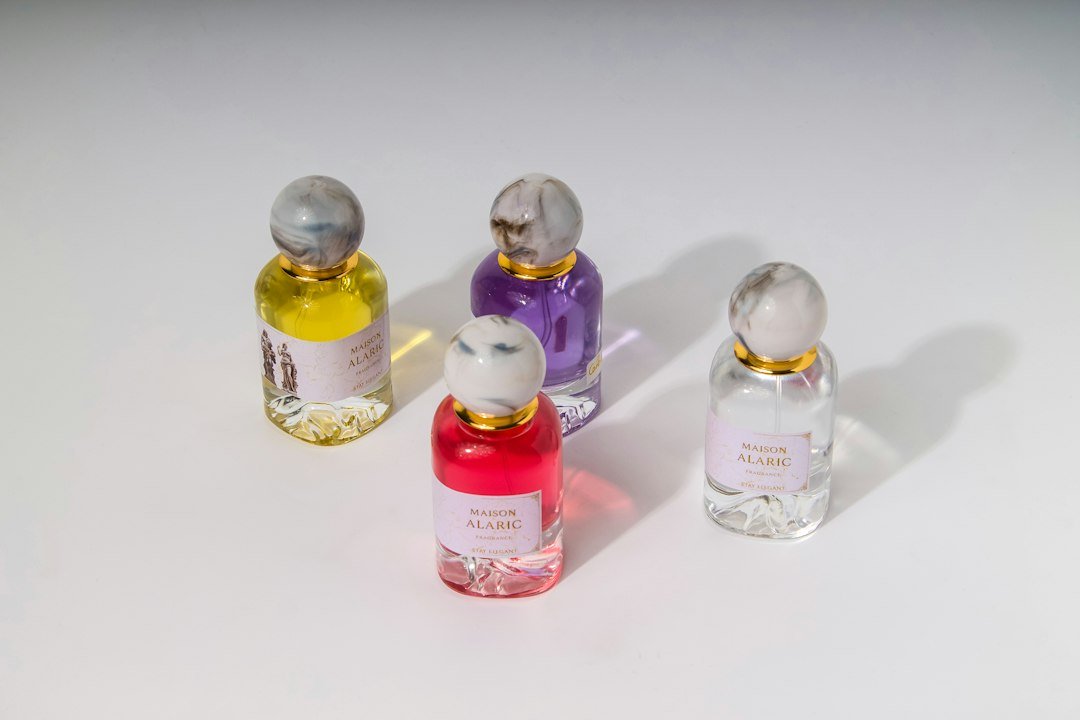 Four colorful perfume bottles arranged on a white surface