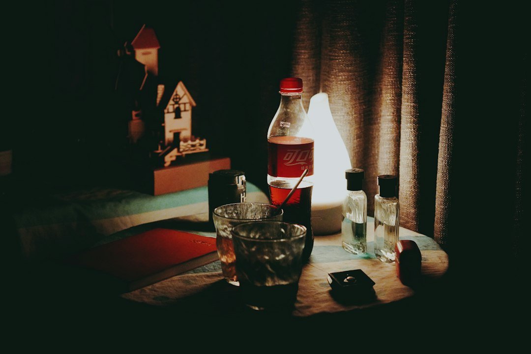 a table topped with bottles of alcohol and a glass