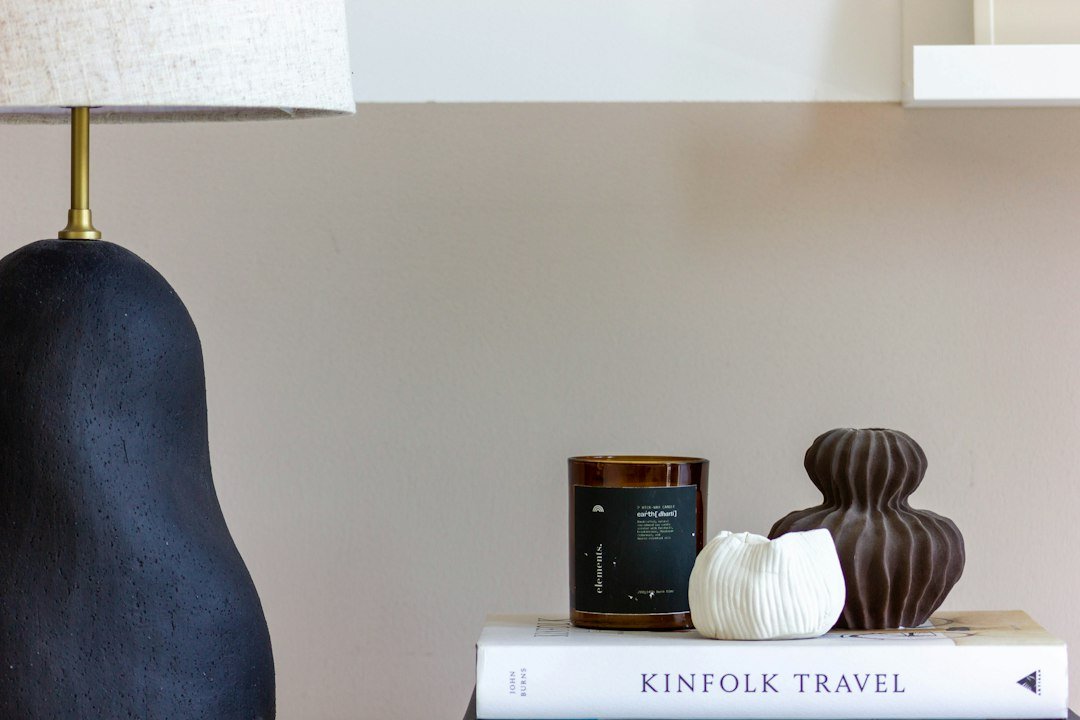 A dark lamp, candle, and decorative objects on books